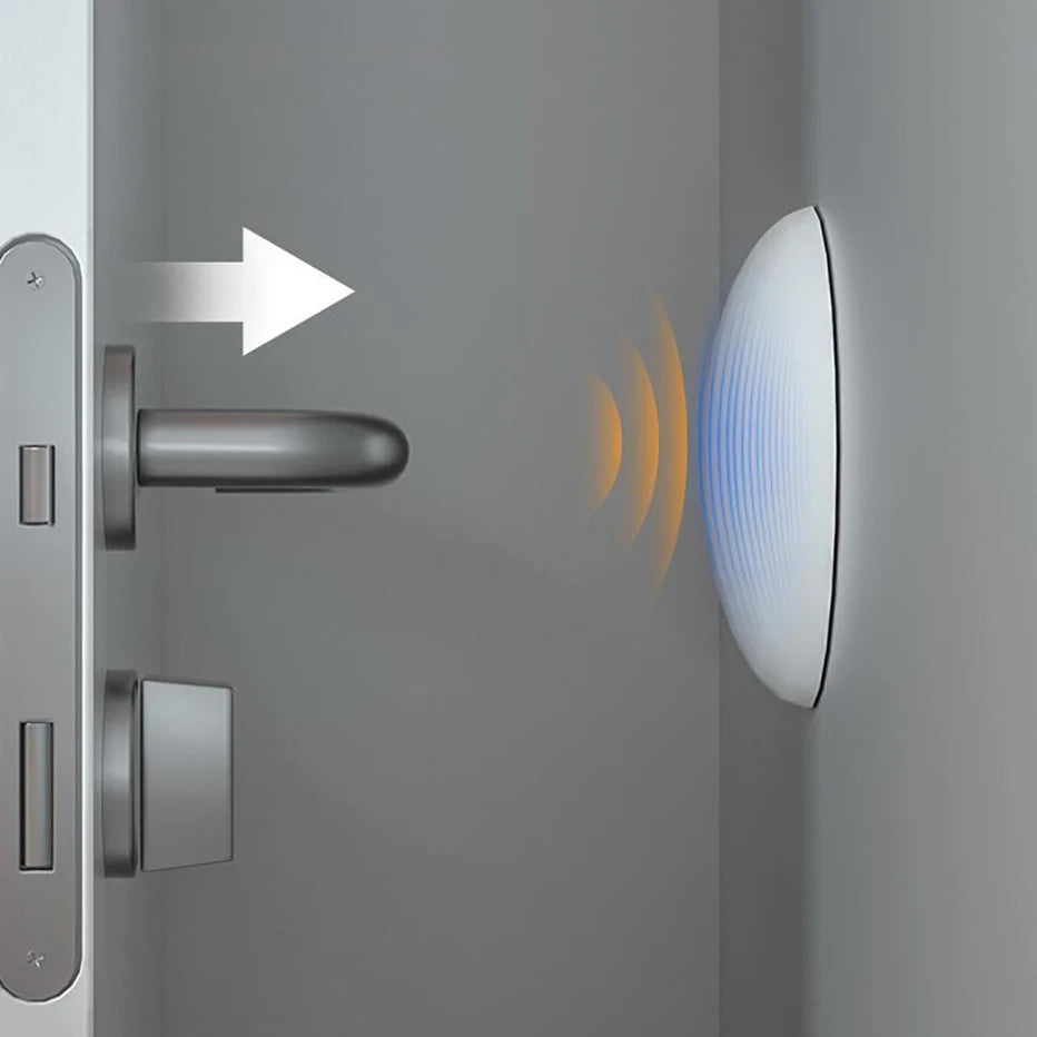 Butée de porte carrée adhésive, anti-choc et résistante, installée près d’une poignée métallique sur une porte blanche — protège efficacement le cadre contre les impacts.