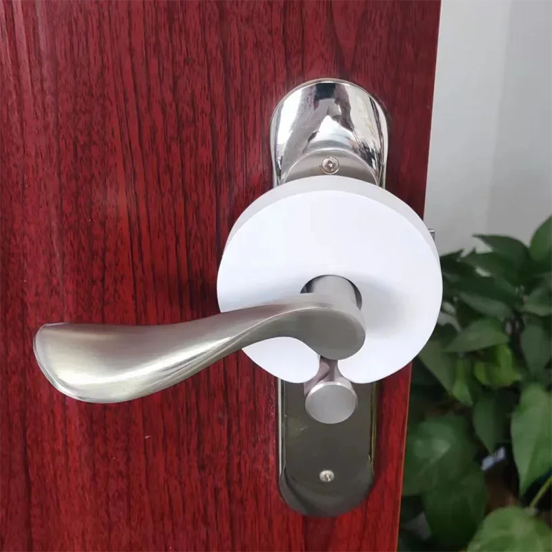 Butée de porte en mousse souple installée derrière une poignée — protège les doigts des enfants contre les pincements, se range facilement et s’installe sans outils.