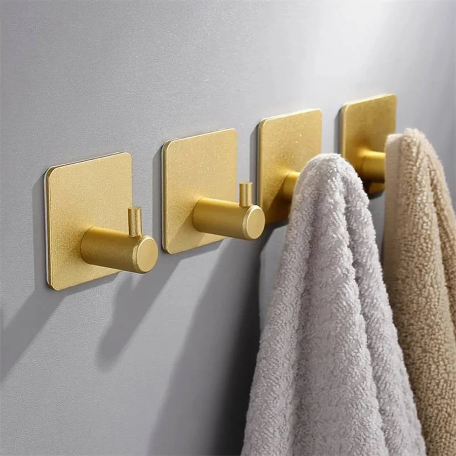 Crochets muraux adhésifs en acier inoxydable, fixés sur une paroi grise. Design moderne et épuré, utilisés pour suspendre vos serviettes. Conviennent à la salle de bain, cuisine ou espace de rangement.